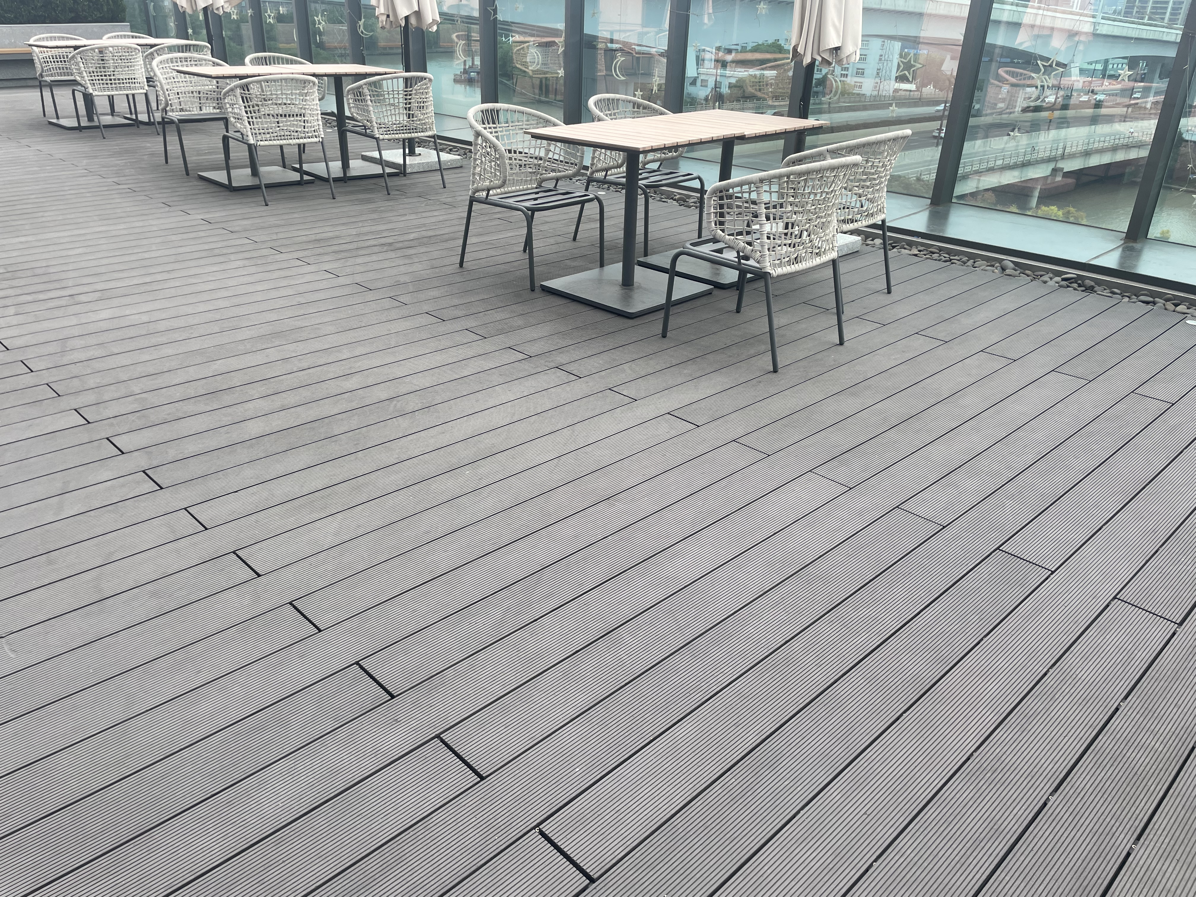 Installatie van lichte composiet terrasplanken waarbij kleur en textuur zichtbaar zijn